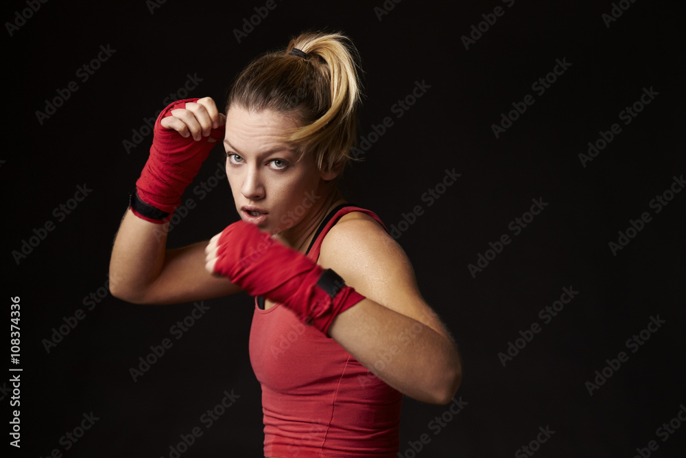 Young blonde woman shadow boxing, in a blocking position Young blonde woman shadow boxing, in a blocking position
