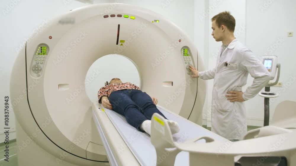 Doctor pushing buttons on mri tomograph Doctor pushing buttons on mri tomograph