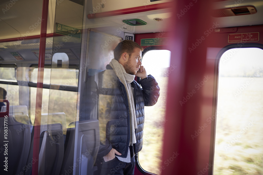 Man Standing In Train Carriage Talking On Mobile Phone Man Standing In Train Carriage Talking On Mobile Phone