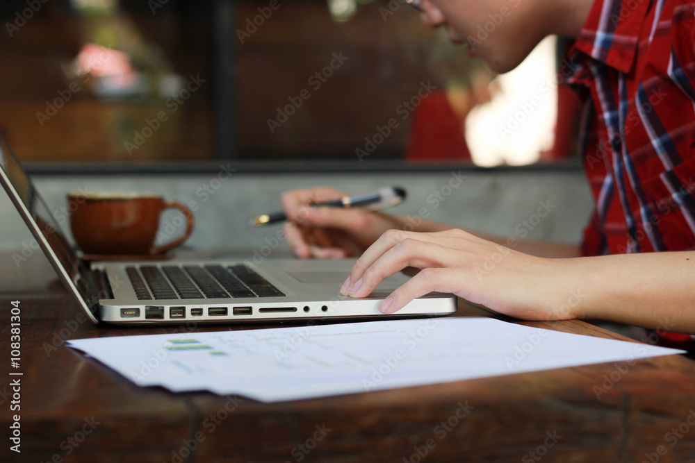 Man typing with laptop at coffee shop