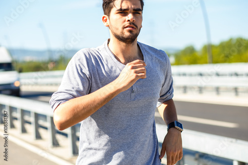 Young man jogging in urban environment.