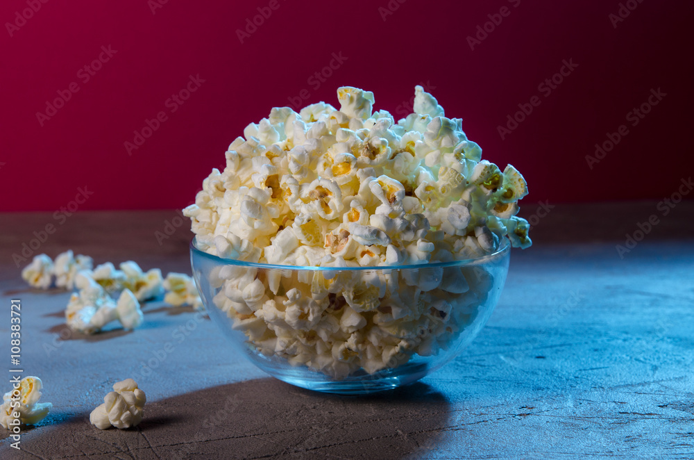 Glass bowl of popcorn on stone table Glass bowl of popcorn on stone table