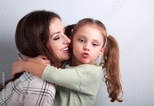Fun bully kid girl showing kiss sign with mother lipstick kiss m