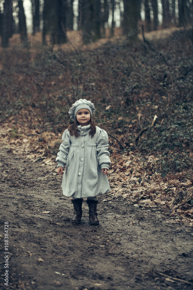 Small girl in autumn forest