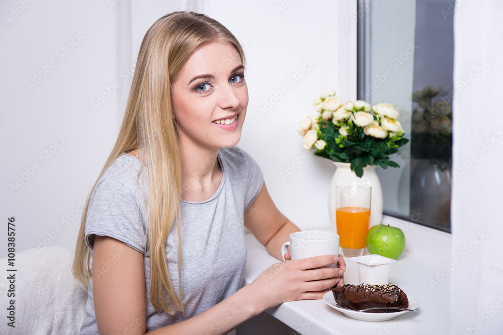 portrait of young woman having breakfast in kitchen portrait of young woman having breakfast in kitchen
