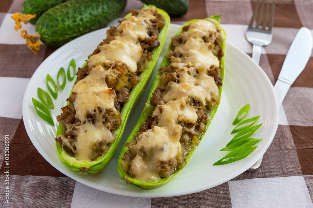 Baked stuffed zucchini, and vegetables on a white plate close up. Dietary lunch. Baked stuffed zucchini, and vegetables on a white plate close up. Dietary lunch.