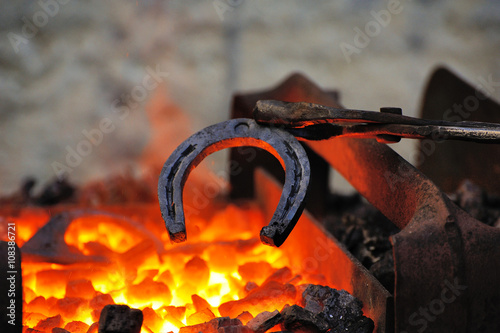 Blacksmith forges a horseshoe