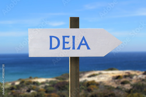 Deia sign with seashore in the background photo