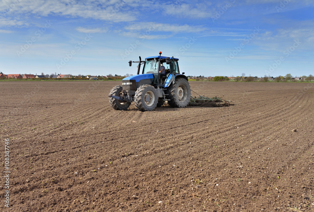 Obraz premium tracteur et sa herse en plein travail