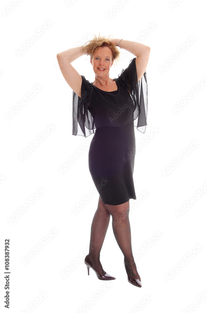 Happy woman in black dress standing.