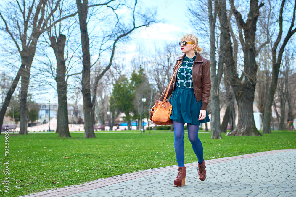 Obraz premium Young woman with bag walking in park