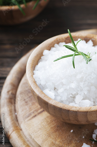 Sea salt and green rosemary in the wooden bowl