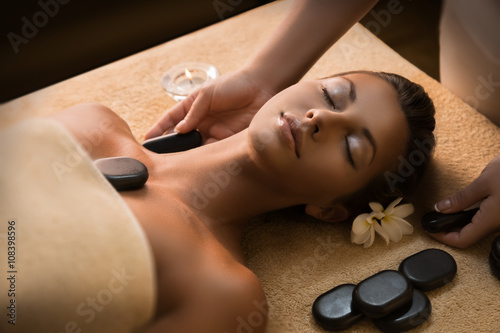 Beautiful girl has stone massage.