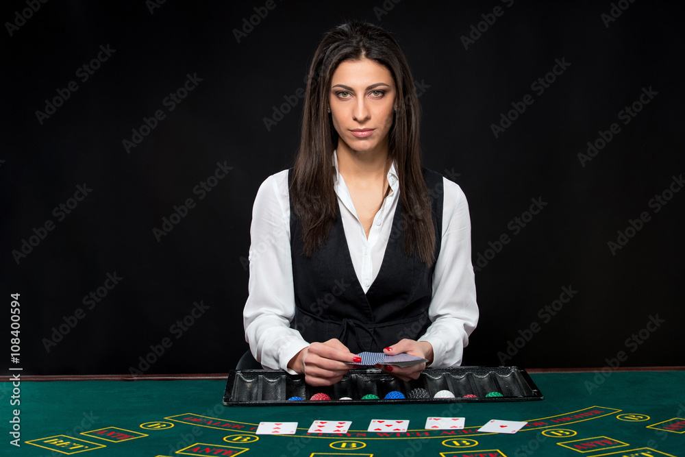 The beautiful girl, dealer, behind a table for poker The beautiful girl, dealer, behind a table for poker