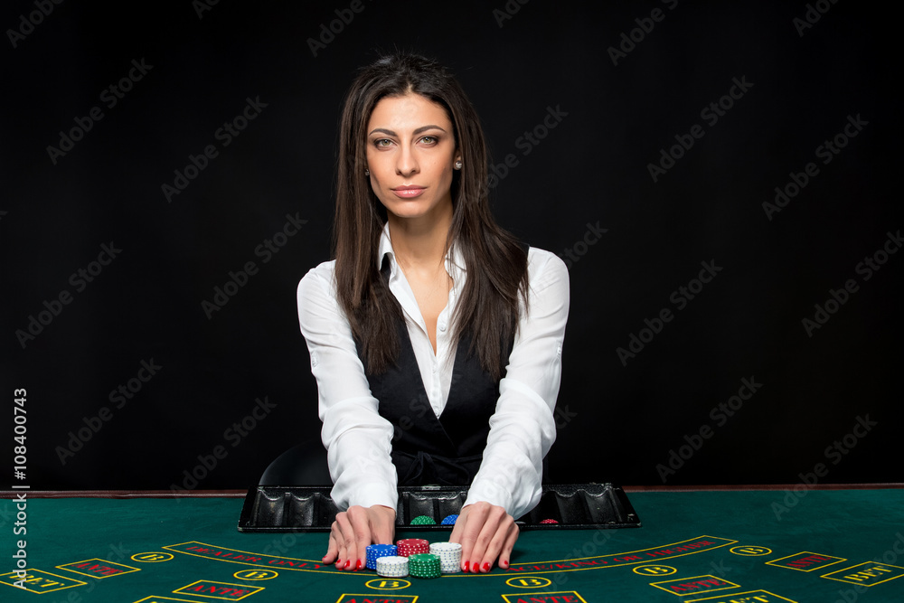 The beautiful girl, dealer, behind a table for poker The beautiful girl, dealer, behind a table for poker