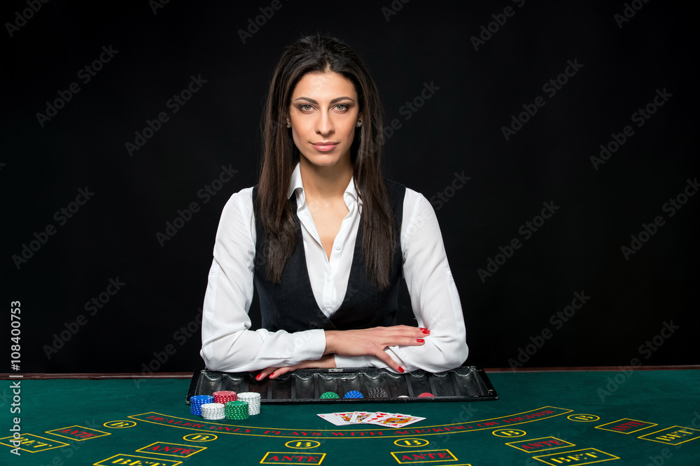 The beautiful girl, dealer, behind a table for poker The beautiful girl, dealer, behind a table for poker
