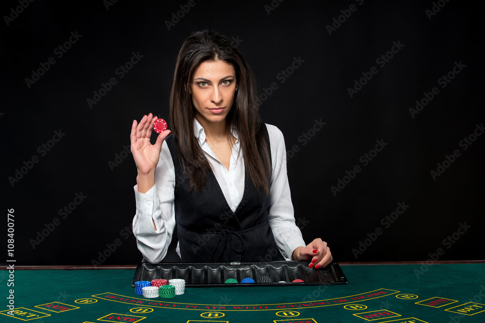 The beautiful girl, dealer, behind a table for poker The beautiful girl, dealer, behind a table for poker