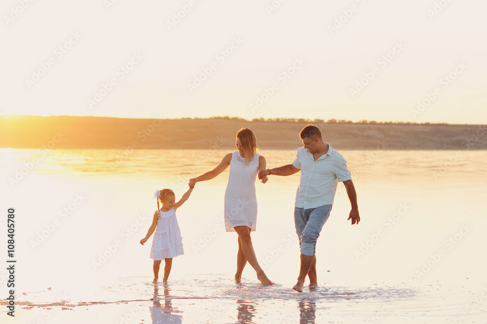 Мама, папа и маленькая дочь грают в море