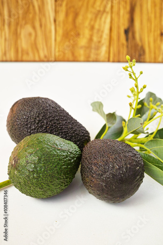 Fresh green avocados with leaves