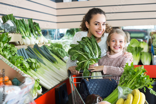 Woman and little girl buying veggies