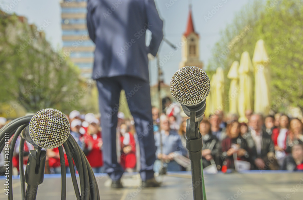 Ταπετσαρία Microphones at political rally with leader and audience in the background