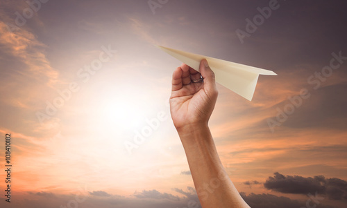 hand preparing to throwing paper plane to mid air  photo