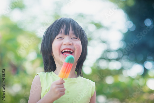 Asian child eating an ice cream outdoors