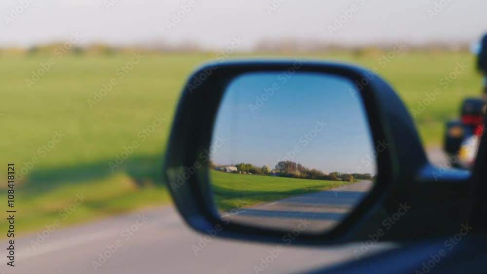 The car ahead of the motorcycle, the view through the rear-view mirror