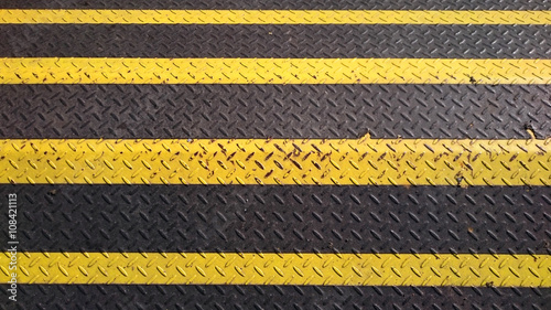 yellow and black warning metal barricade with pattern