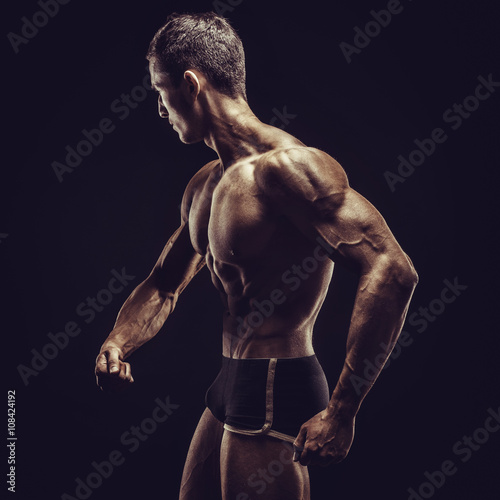 Bodybuilder man posing, showing perfect abs, houlders, biceps, triceps, chest photo