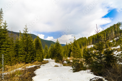 Spring valley landscape with mountains and melting snow