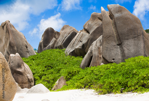 Typical rocks of Seychelles with bushes and sandy beach