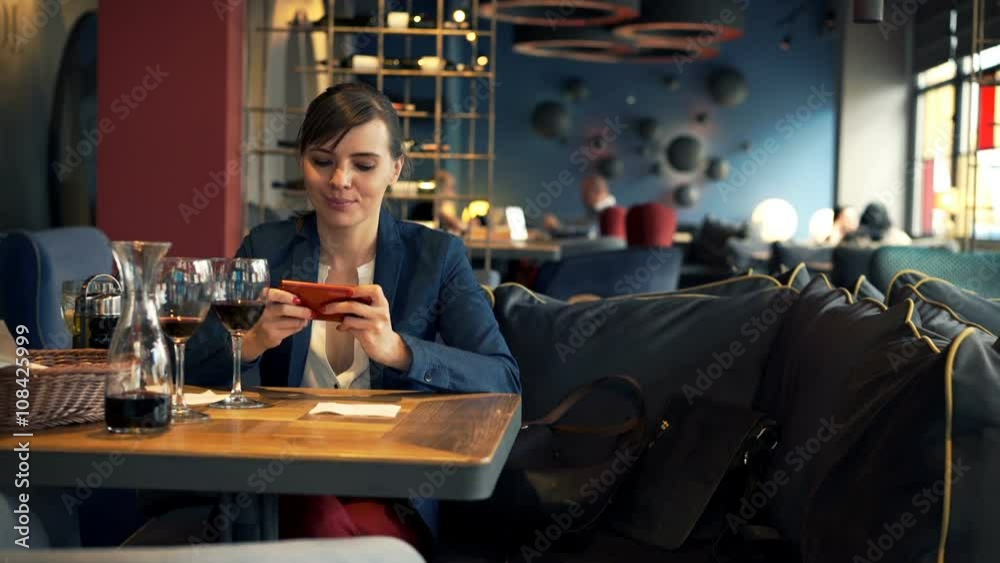 Happy woman playing game on smartphone sitting in cafe
Happy woman playing game on smartphone sitting in cafe