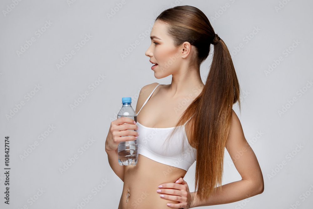 sporty woman over gray background drinking water sporty woman over gray background drinking water