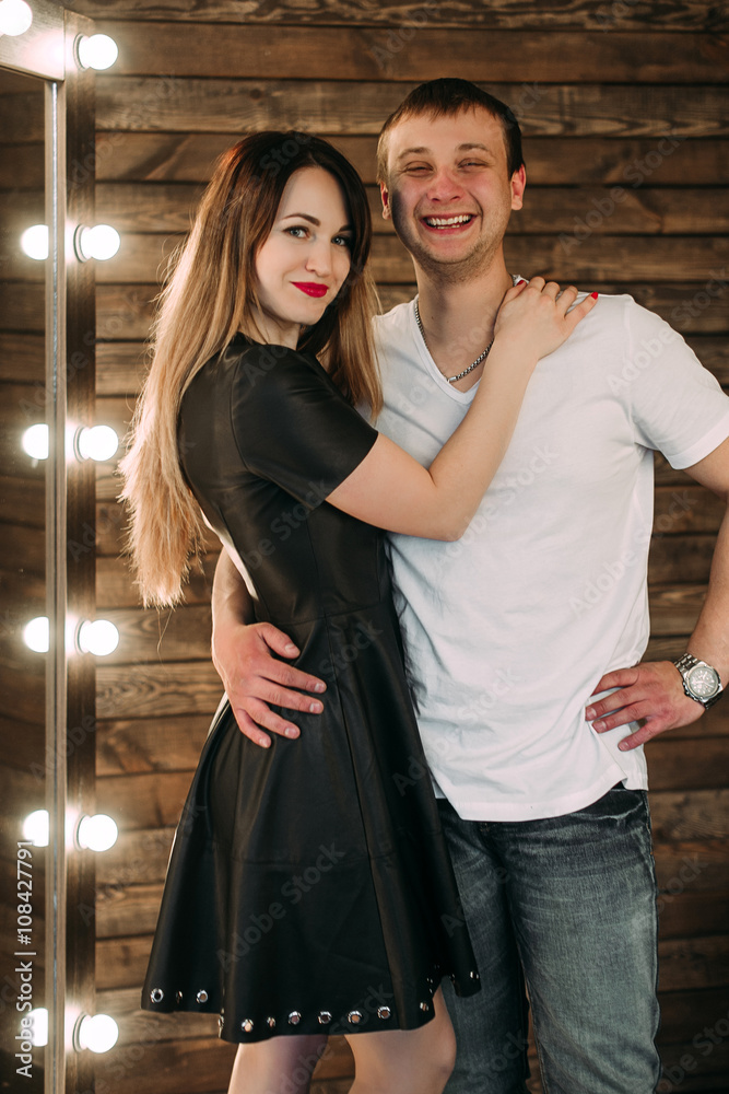 Portrait of young couple in love posing at studio dressed in classic clothes