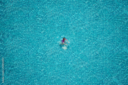 Top view of girl swimming in the pool.