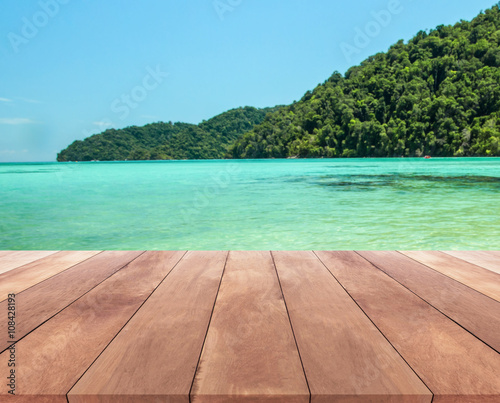 wood table top and blue sky with seascape background
