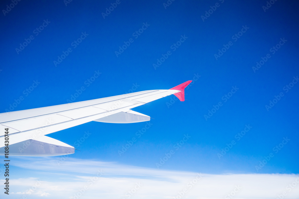 View from airplane window with blue sky and white clouds View from airplane window with blue sky and white clouds