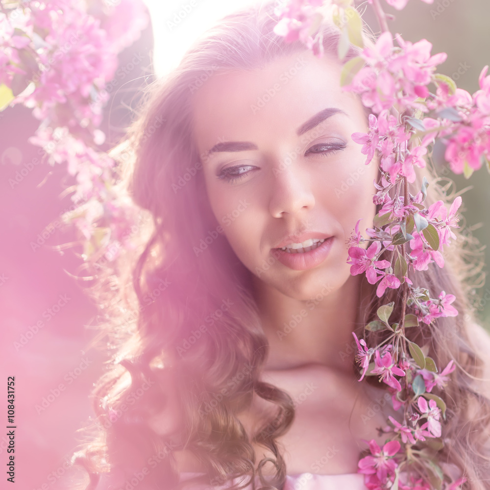 Beautiful woman in a pink flowering trees