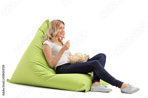 Girl eating popcorn seated on beanbag