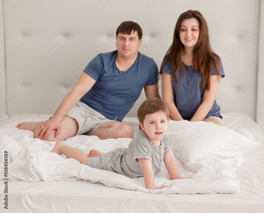 little boy and parents On Parents Bed Wearing Pajamas