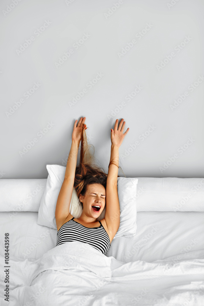 Morning Wake Up. Smiling Young Woman Waking Up Fully Rested On White Bedding. Model Stretching In Bed. Girl Lying, Relaxing In Bedroom. Healthy Sleep, Lifestyle. Wellness, Health, Beauty Concept Morning Wake Up. Smiling Young Woman Waking Up Fully Rested On White Bedding. Model Stretching In Bed. Girl Lying, Relaxing In Bedroom. Healthy Sleep, Lifestyle. Wellness, Health, Beauty Concept