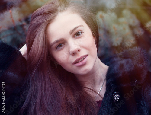 Bilde på lerret Beautiful brown-eyed brunette girl  winter  black coat posing  background trees,