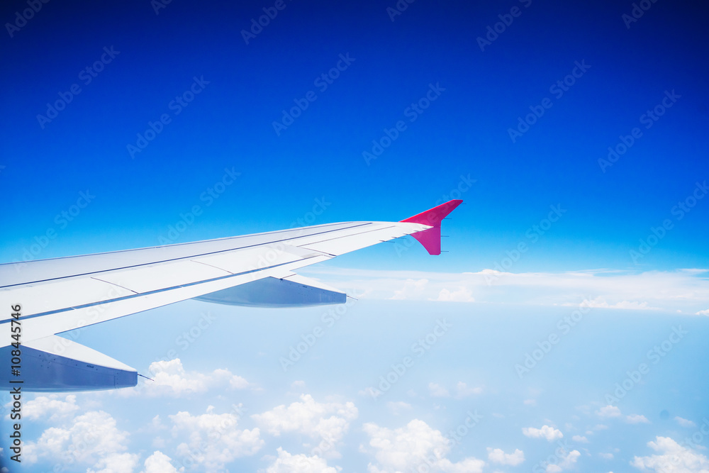 Fototapeta premium View from airplane window with blue sky and white clouds