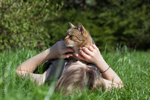 Obraz na płótnie Woman petting cat in the garden
w salonie