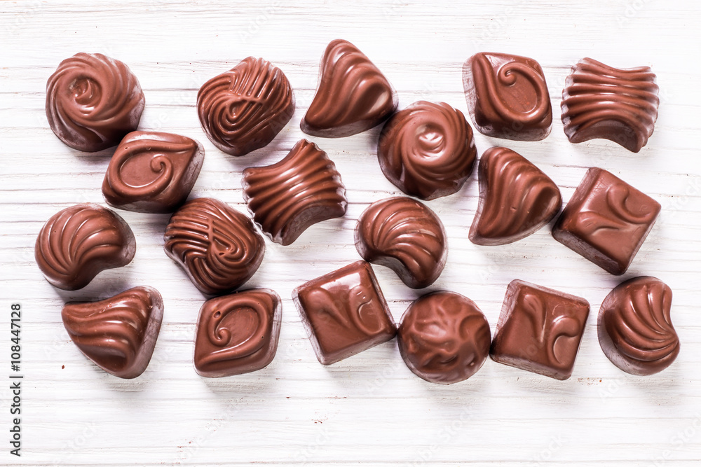 Delicious chocolate candies on wooden background