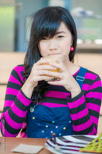 Young asian beautiful woman drinking fresh orange juice