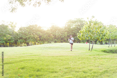Young fitness asian woman running at green grass © themorningglory