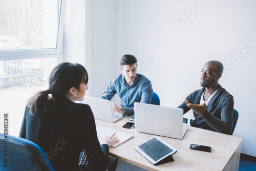 Group of contemporary multiethnic business people working together using multimedia devices like smart phone and tablet - working, business, start up concept