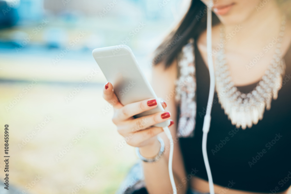 Close up on the hand of young woman holding a smart phone, tapping and scrolling the touchscreen - technology, social network, communication concept